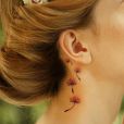 Un tatouage derrière l'oreille : des fleurs des champs