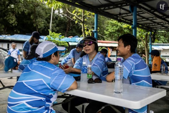 Kitty Lau (centre) discute avec des amis avant un entraînement de son équipe de bateau-dragon, le 25 mai 2024 à Hong Kong