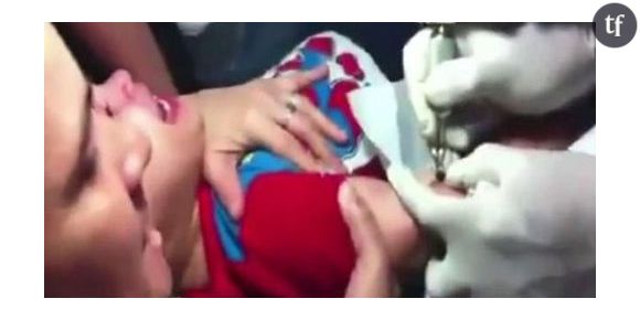 Une mère force son enfant à se faire un tatouage - Vidéo