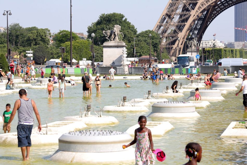 Canicule 2015 : les Parisiens viennent chercher de la fraîcheur dans la fontaine du Trocadéro et celle du Champ de Mars. 