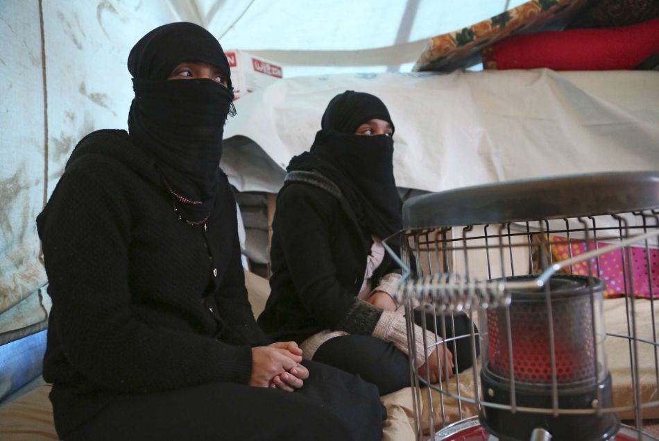 Deux femmes Yézidi, chassées de leur maison par l'Etat islamique, se réchauffent dans leur tente le 10 janvier 2015.