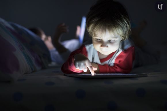 Un enfant face à un écran avant le coucher.