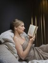 Une femme se détend en lisant un livre avant le coucher.
