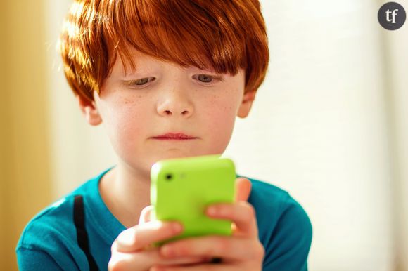 Enfant entrant un numéro sur son téléphone