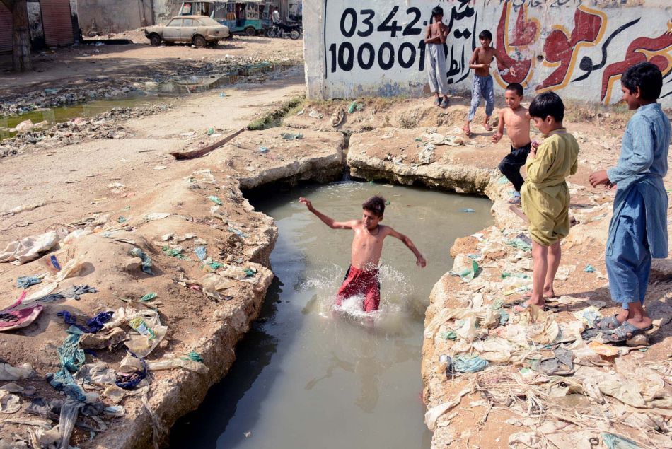 A Karachi, au Pakistan, des enfants tentent de se rafraîchir dans l'eau. 2020.