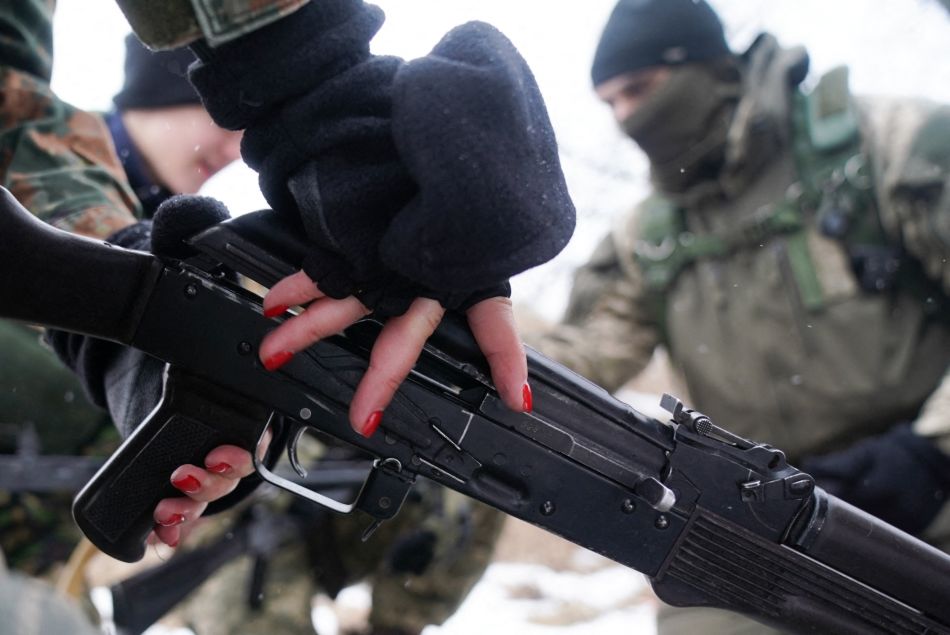 Une volontaire de la force de protection civile d'Obukhiv apprend à manier une arme automatique. Février 2022, Obukhiv, Ukraine.