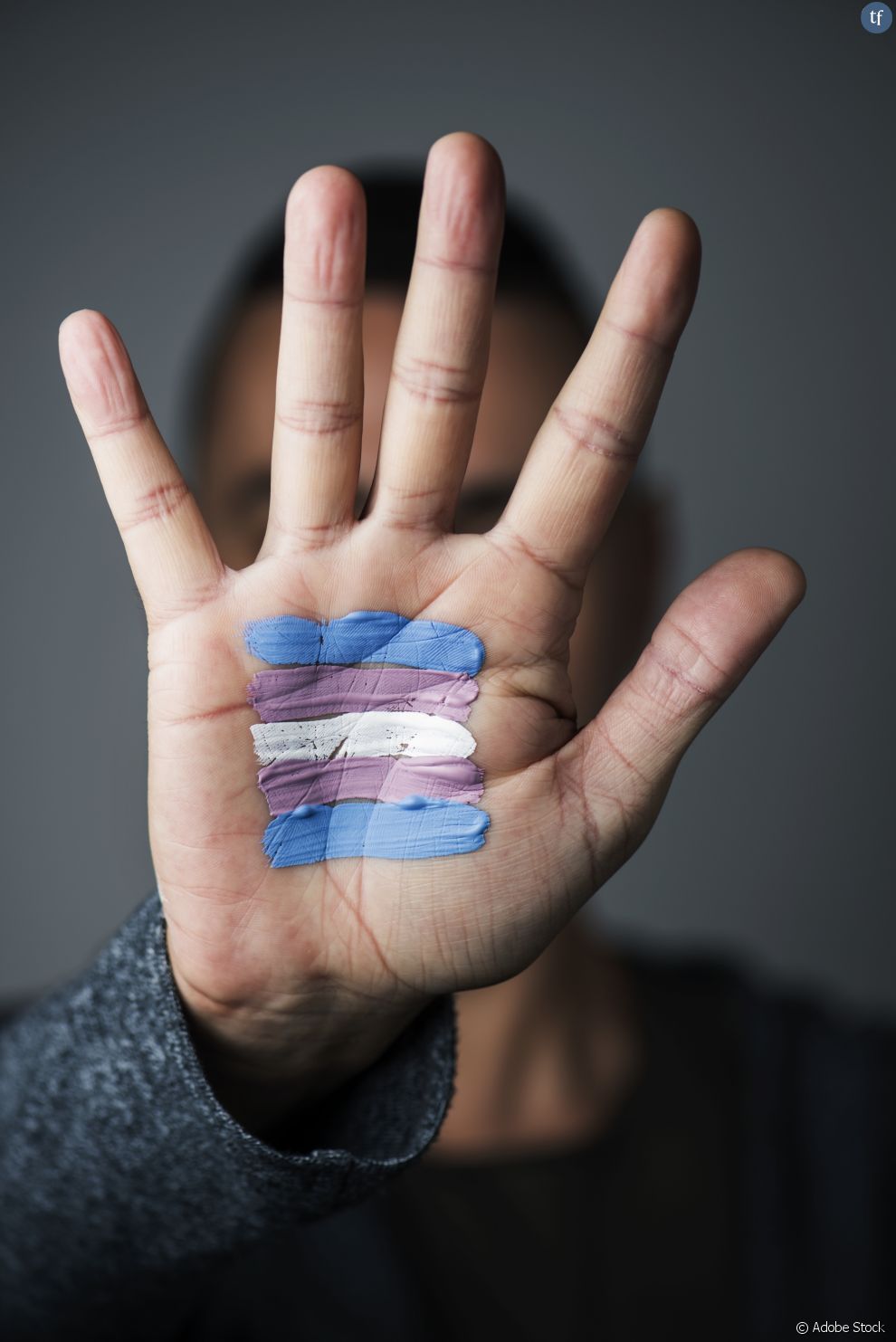Un symbole transgenre peint sur une main