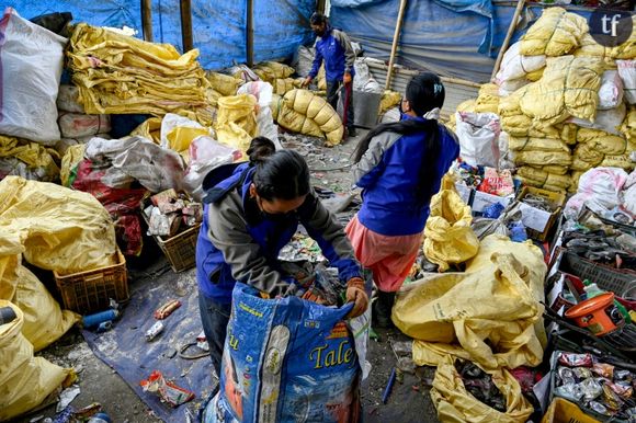Sur cette photo prise le 12 juin 2024, des ouvriers trient les déchets récupérés sur le mont Everest pour les recycler à Katmandou. Des tentes fluorescentes, du matériel d'escalade hors d'usage, des bouteilles de gaz vides et même des excréments humains jonchent la route qui mène au sommet