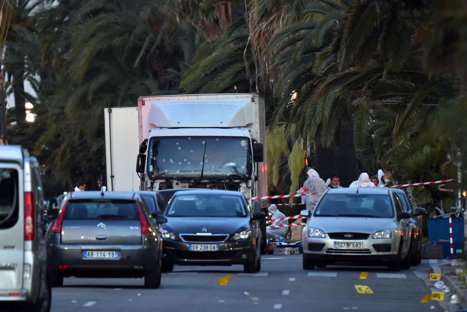 Les officiers de la police judiciaire enquêtent autour du camion criblé de balles qui a tué plus de 84 personnes sur la promenade des anglais à Nice le 15 juillet 2016