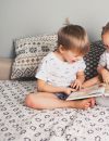 Deux enfants qui lisent un livre en rigolant