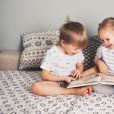 Deux enfants qui lisent un livre en rigolant