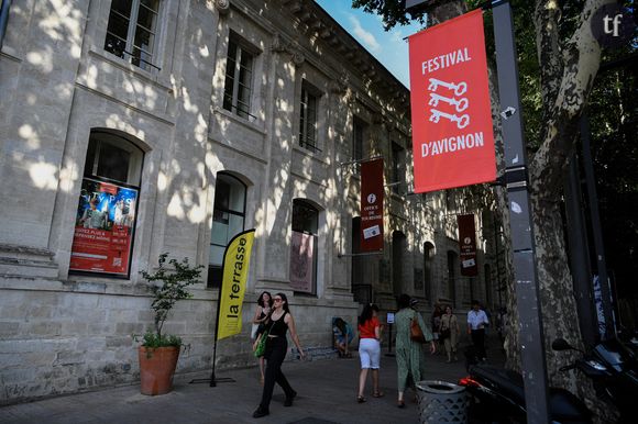 Des violences qui ont été observées... Durant trois représentations de la pièce. Celle-ci a pris place d 20 au 25 juillet au Gymnase du lycée Aubanel. Certains interprètes auraient également été victimes d'agressions dans les rues de la ville. Une atmosphère très étouffante donc, et tout à fait déplorable.
Les piétons passent devant l'Office de Tourisme pendant le Festival. Le Festival d'Avignon a débuté en France, offrant un mois de célébration du théâtre dans la cité médiévale. Organisée au centre d'Avignon, cette 77e édition propose un programme diversifié de spectacles. Photo par Igor Ferreira/SOPA Images/SPUS/ABACAPRESS.COM