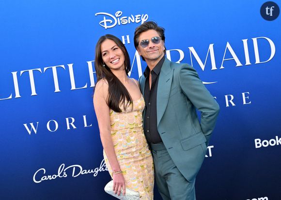 Et la star d'ajouter : "Je pense qu'à l'époque je me suis juste dit : 'Ah, c'est donc ça les filles'...". 
Caitlin McHugh et son mari John Stamos au photocall de la première du film "La Petite Sirène" au Dolby Theatre à Hollywood, Los Angeles, Californie, etats-Unis, le 8 mai 2023. 