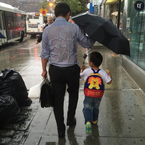 Cette photo d'un père protégeant son fils de la pluie fait le tour du monde.