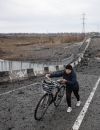  Une femme traverse un pont détruit à l'entrée de Borodianka après une attaque russe en Ukraine 