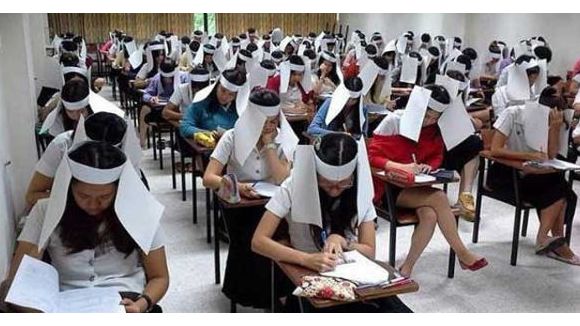 Des étudiants thaïlandais affublés de chapeaux en papier pour éviter la triche