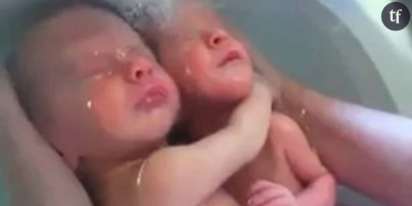 Des jumeaux prennent un bain, enlacés comme dans le ventre de leur mère