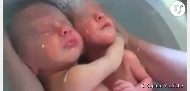 Des jumeaux prennent un bain, enlacés comme dans le ventre de leur mère