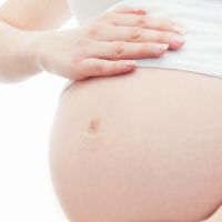 Une femme enceinte se frappe le ventre avec un marteau