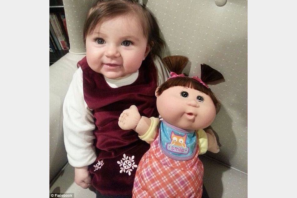Cette petite fille à couettes n'est-elle pas à croquer avec sa poupée ?