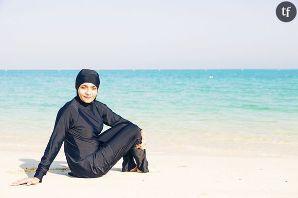 Une femme en burkini au bord de la plage