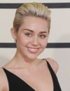 Miley Cyrus plaque ses cheveux vers l'arrière pour dégager son visage.