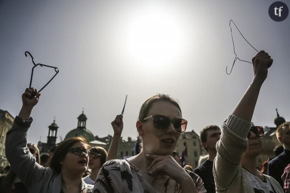 Ds femmes qui manifestent pour l'avortement brandissent un cintre, triste symbole des meurtriers avortements clandestins