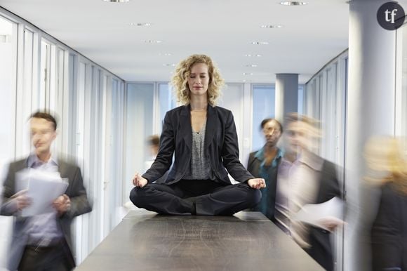 Phot d'illustatrion d'une femme en pleine méditation au travail.