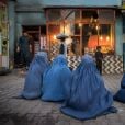 En Afghanistan, des femmes en burqa mendient devant une boulangerie.