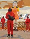 Le personnel d'un centre commercial joue le rôle des personnages du jeu du calmar à Yantai, dans la province de Shandong, le 13 novembre 2021.