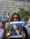 Une manifestante tient un panneau sur lequel on peut lire ''#Mahsaamini'' en solidarité avec le soulèvement des femmes en Iran à Washington Square Park, à New York