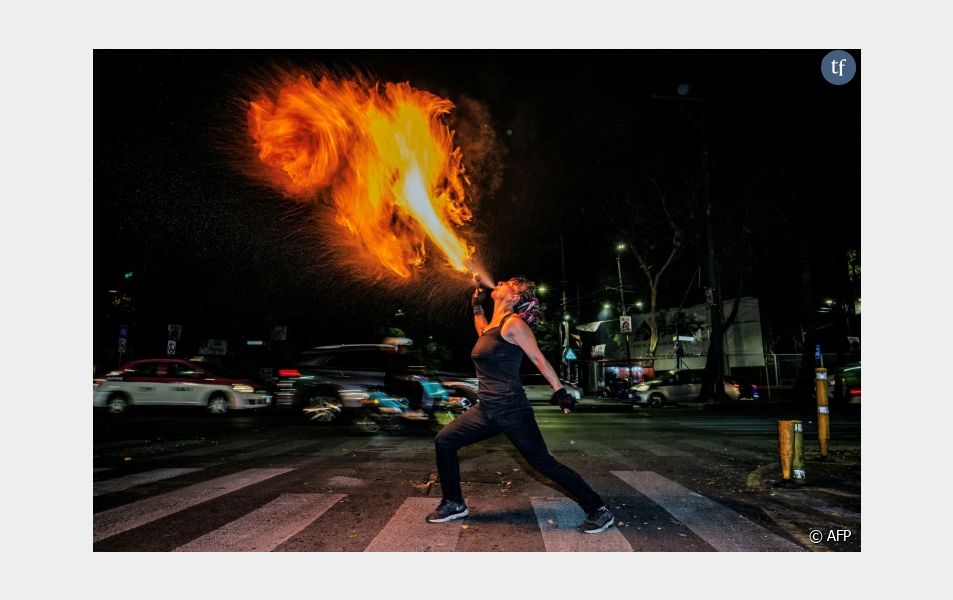 L'activiste féministe et artiste de rue "Flor de Fuego" crache du feu dans une rue de Mexico le 15 mai 2024
