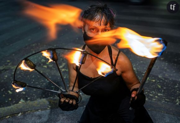 L'activiste et féministe "Flor de Fuego" (Fleur de feu) jongle avec des torches de feu à un carrefour de Mexico le 15 mai 2024