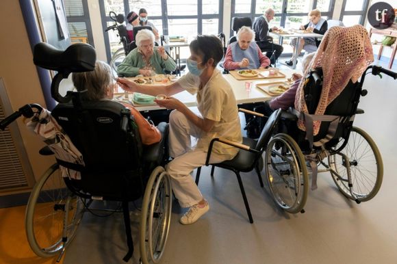 Une employée aide une pensionnaire à manger, le 23 mars 2022, à l'Ehpad public "Pays Vert" à Mauriac (Cantal), qui a mis en place un dispositif pour scruter ce qui est mangé chaque jour par les résidents et lutter ainsi contre la dénutrition