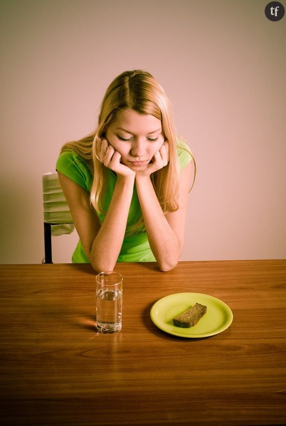 Jeune femme très mince boudant son assiette