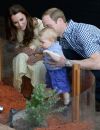 Le prince George entouré de ses deux parents en Australie.