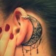 Tatouage derrière l'oreille : une fleur de lotus et une lune