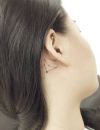 Tatouage derrière l'oreille : constellation