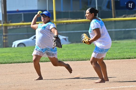 Sitlali Poot (d), capitaine de "Las Amazonas de Yaxunah", une équipe féminine de softball de la région du Yucatan, au Mexique, jouant pieds nus et en robes traditionnelles, et une coéquipière participent à un match amical contre l'équipe féminine de softball du lycée de Walnut, le 31 mai 2024 en Californie