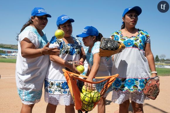 Des membres de "Las Amazonas de Yaxunah", une équipe féminine de softball de la région du Yucatan, au Mexique, jouant pieds nus et en robes traditionnelles, s'échauffent avant un match amical contre l'équipe féminine de softball du lycée de Walnut, le 31 mai 2024 en Californie