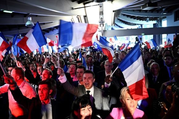 Des militantes et militants RN fêtent le score aux élections européennes de leur parti, le 9 juin 2024, à Paris