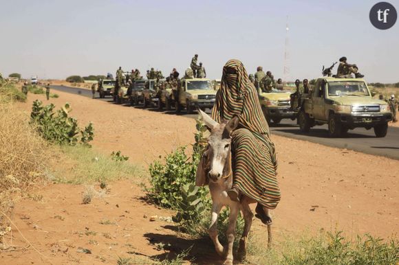 Une femme photographiée en novembre 2014 alors qu'un convoi des troupes gouvernementales passe le village de Tabit dans le nord Darfour, au Soudan.