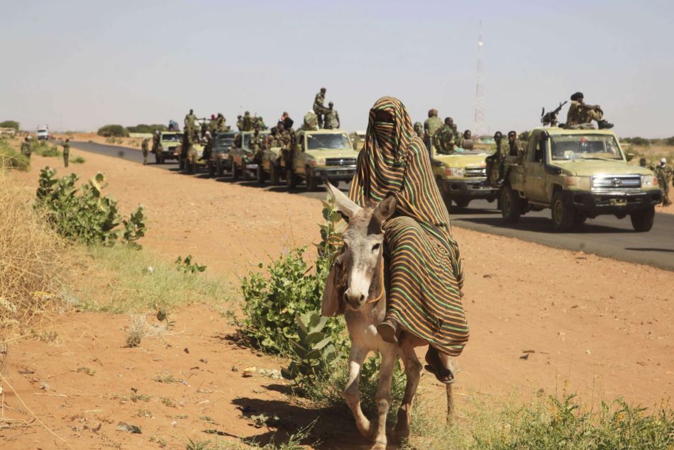 Une femme photographiée en novembre 2014 alors qu'un convoi des troupes gouvernementales passe le village de Tabit dans le nord Darfour, au Soudan.