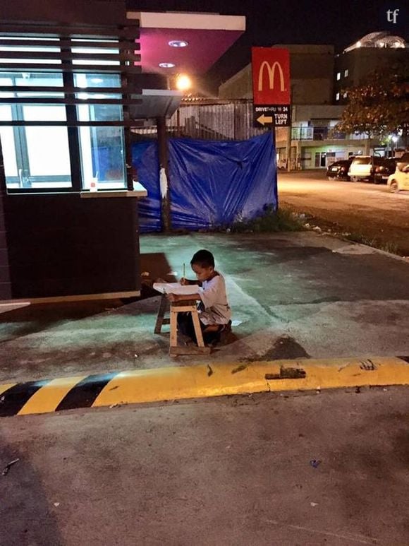 Le petit Daniel fait ses devoirs dans la rue sur lîle de Cebu, aux Philippines.