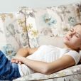 Une femme allongée dans un canapé à cause de crampes menstruelles