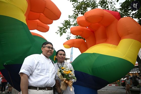 Le couple birman queer Nyan (g) et Mae (d) posent pour une photo, lors de la marche des fierté de Chiang Mai, en Thaïlande, le 26 mai 2024