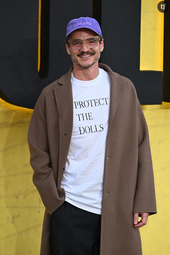 Pedro Pascal est arrivé vêtu d'un manteau marron, et d'un t-shirt blanc floqué "Protect the dolls" ("protègez les poupées").