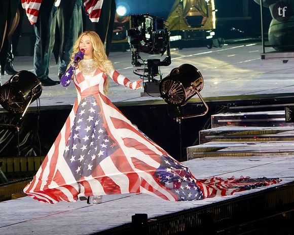 La chanteuse apparaît dans un ensemble en jean strassé, pantalon évasé et veste moulante.