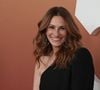 Julia Roberts arbore des cheveux mi-longs blonds coiffés avec la raie sur le côté et de larges ondulations sophistiquées.